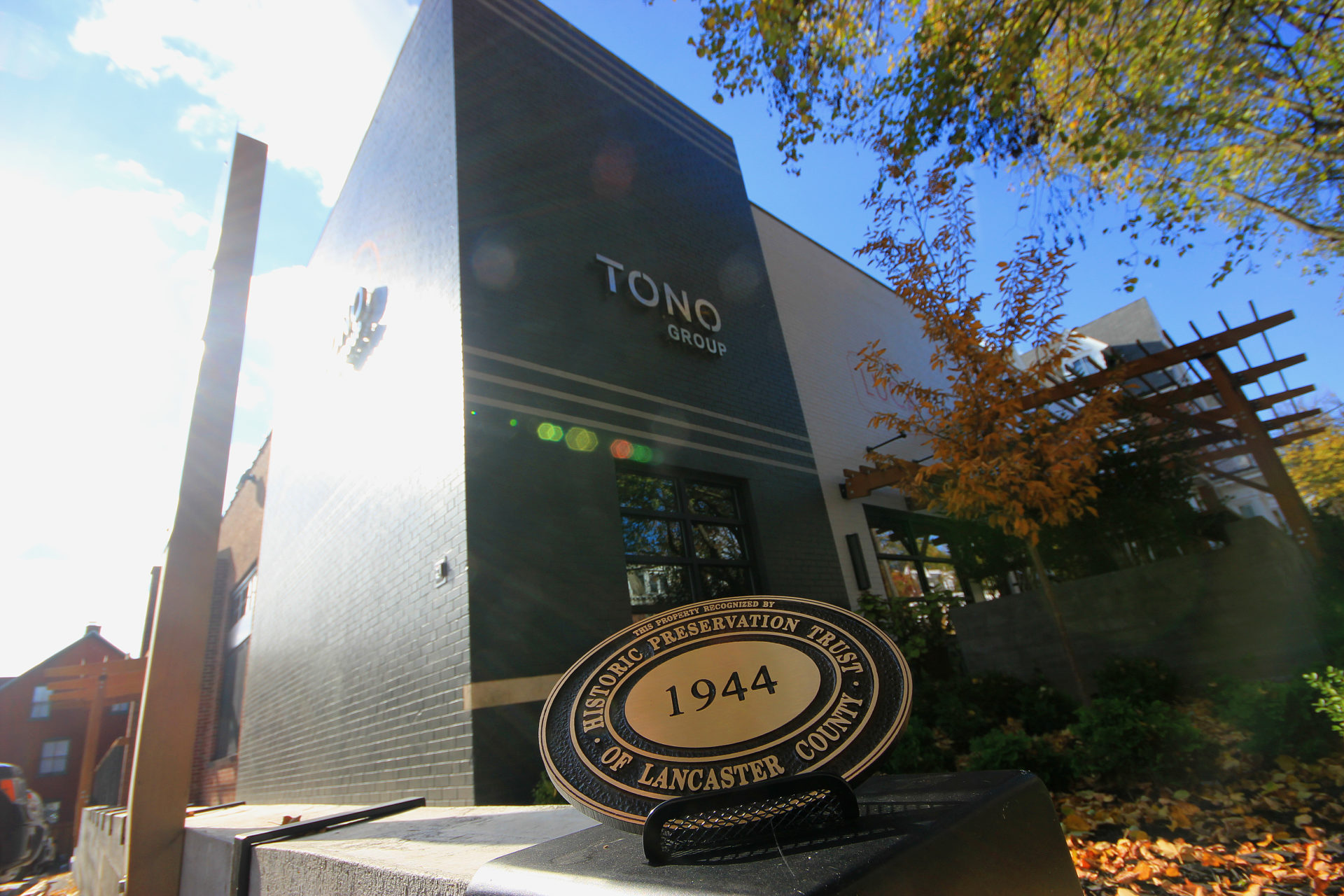 C. Emlen Urban award displayed in front of TONO Group facility