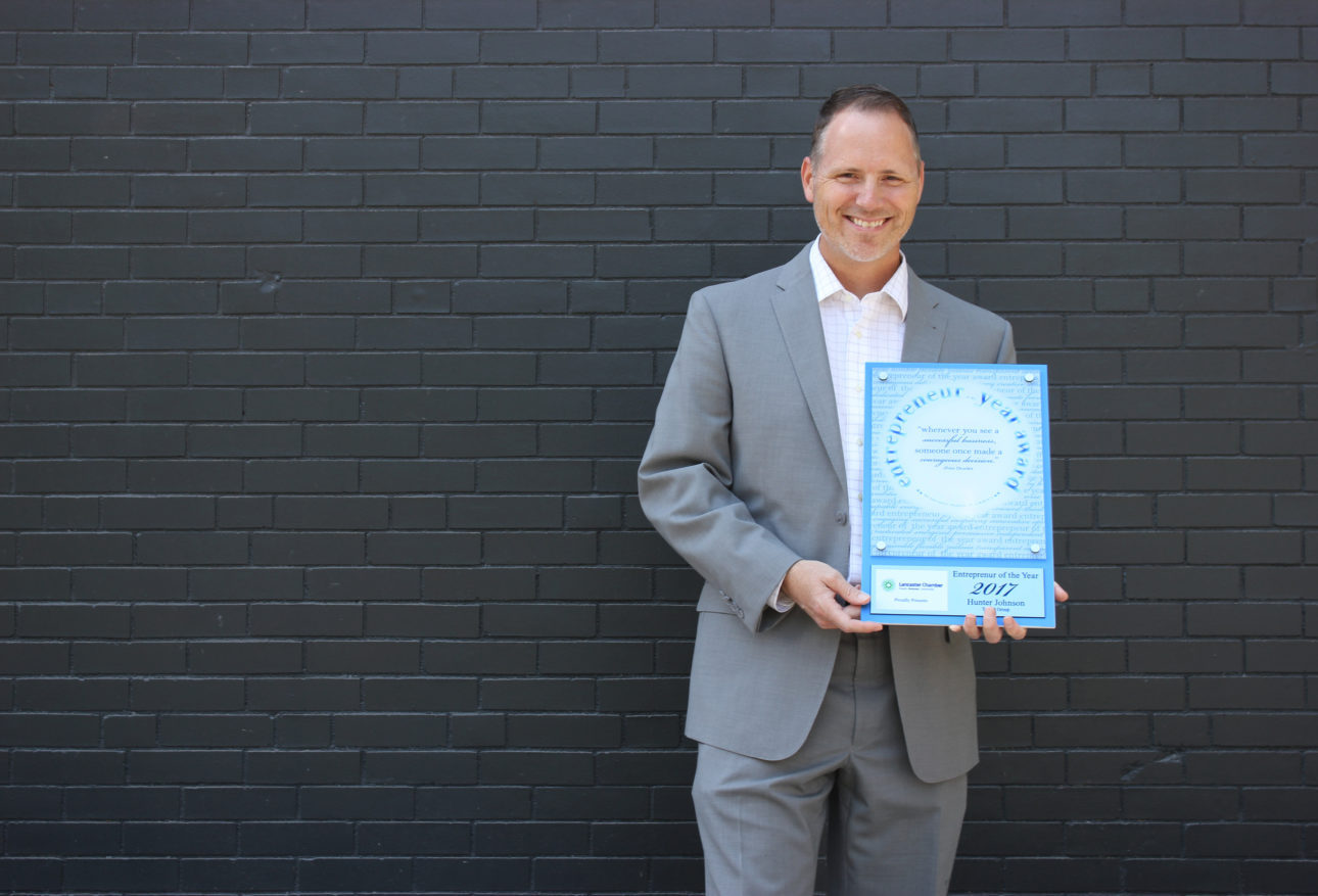 Hunter Johnson holding Entrepreneur of the Year award